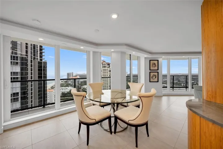 Dining space with plenty of natural light, light tile patterned floors, and a wall of windows