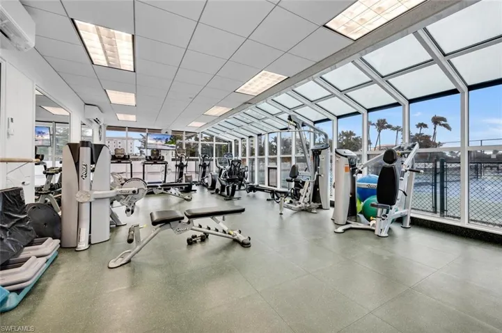 Workout area featuring a wall mounted AC and a wall of windows