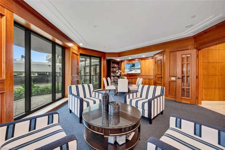Library featuring ornamental molding, wood walls, and carpet