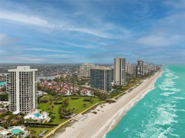 Birds eye view of property with a view of the beach and a water view