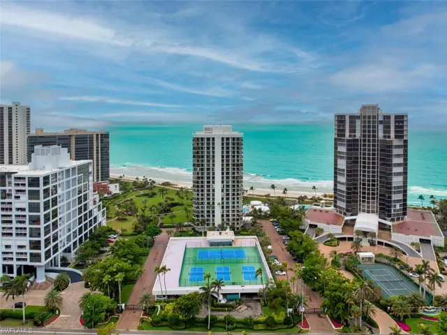 Birds eye view of property featuring a beach view and a water view