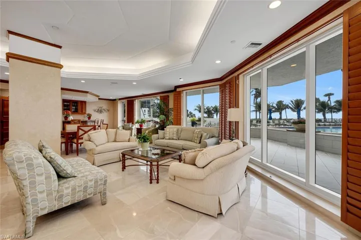 Community room with ornamental molding, a raised ceiling, and a water view