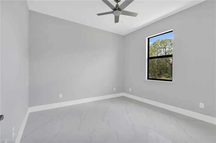 Empty room featuring marble finish flooring and ceiling fan
