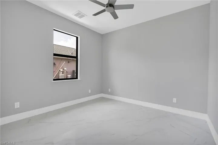 Empty room with marble finish floors and ceiling fan