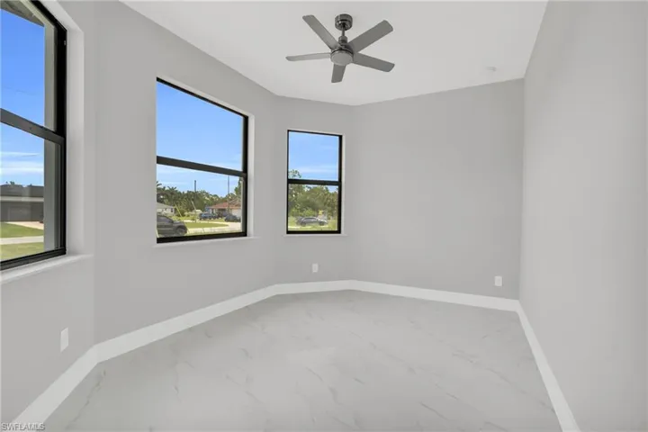 Spare room featuring marble finish flooring and ceiling fan