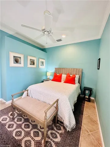 Bedroom featuring ornamental molding, light tile patterned floors, and ceiling fan