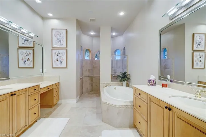 Bathroom with plus walk in shower, tile patterned flooring, and vanity