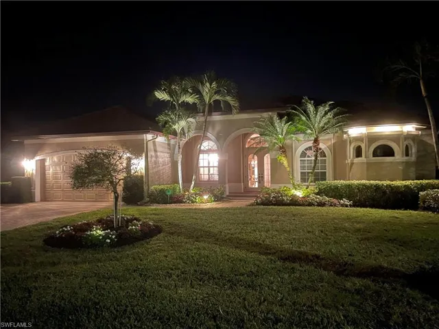 Mediterranean / spanish house featuring a garage and a yard
