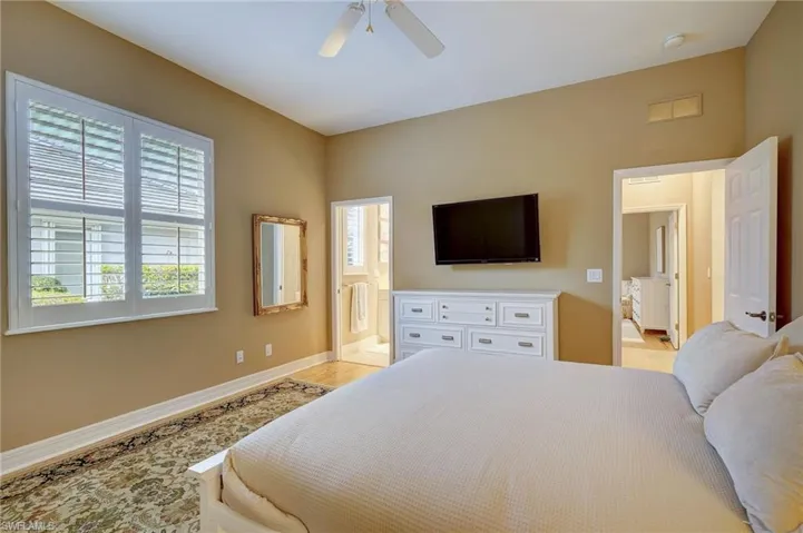 Bedroom #2 with connected bathroom, light hardwood / wood-style floors, multiple windows, and ceiling fan
