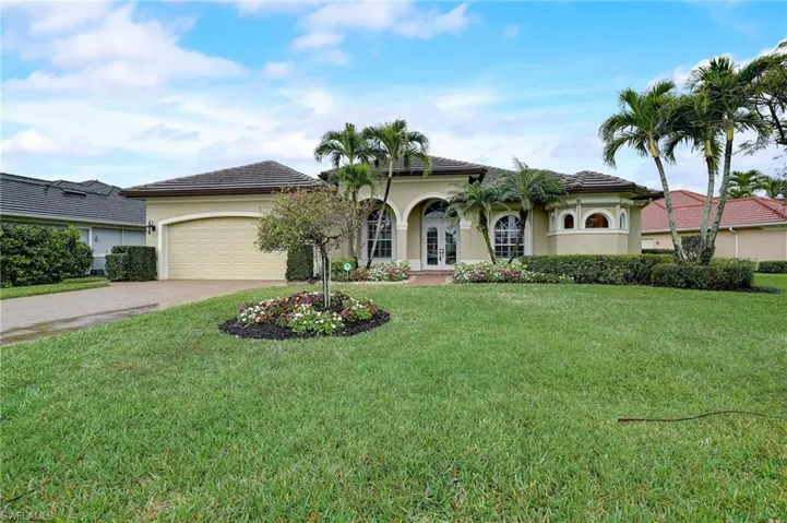 View of front facade featuring a garage and a front yard