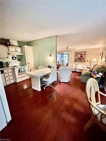 Living room featuring ceiling fan and a textured ceiling
