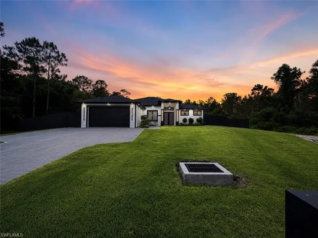 Contemporary single-story residence with a black tile roof and white siding