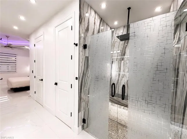 Contemporary shower enclosure featuring frosted glass panels and a ceiling-mounted matte black rainfall showerhead
