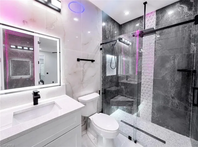 Modern bathroom featuring a glass-enclosed shower with matte black fixtures
