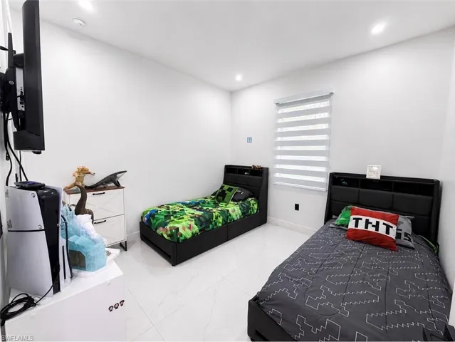 White tile flooring, recessed ceiling lighting, a window with horizontal blinds, and clean white walls