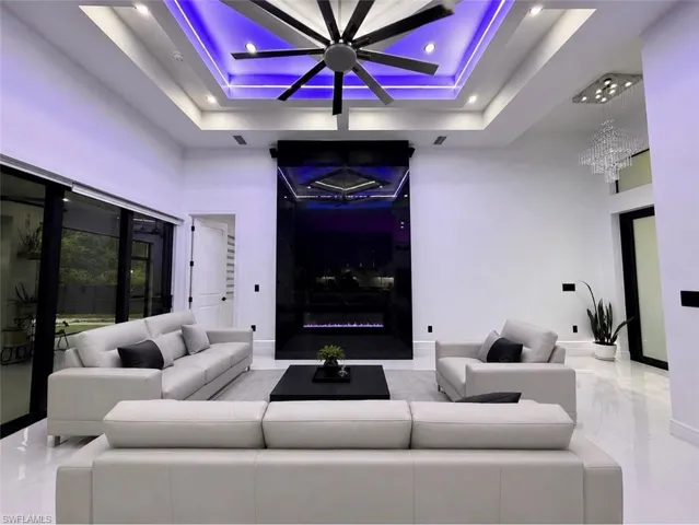 Recessed lighting and a multi-blade ceiling fan complement the tray ceiling with ambient lighting