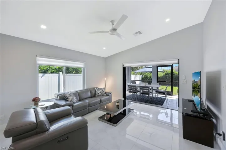Living area featuring recessed lighting, plenty of natural light, lofted ceiling, ceiling fan, and light tile patterned flooring