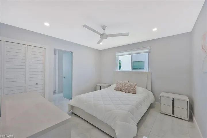 Bedroom featuring ceiling fan, recessed lighting, a closet, and light marble finish flooring
