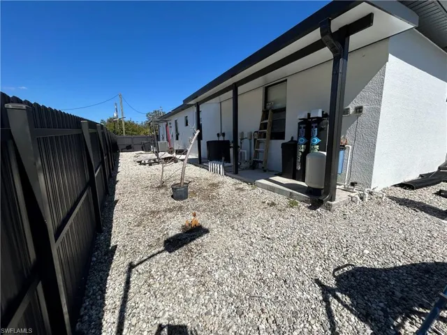 View of side of home with stucco siding, a fenced backyard, and a patio area