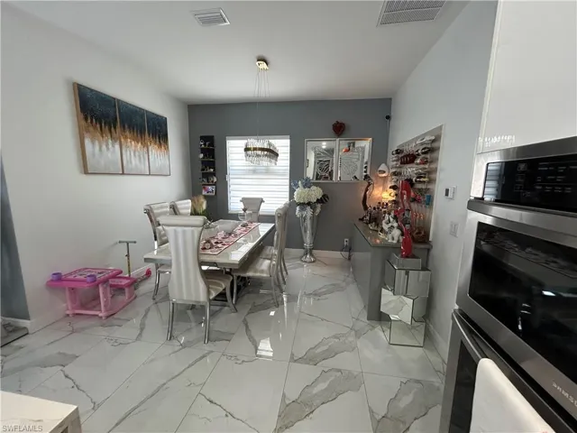 Dining room featuring light marble finish flooring and hanging lights