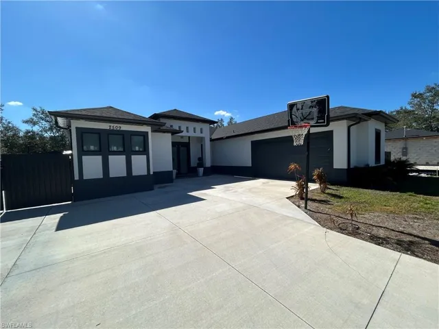 Prairie-style house with driveway, a garage, and stucco siding