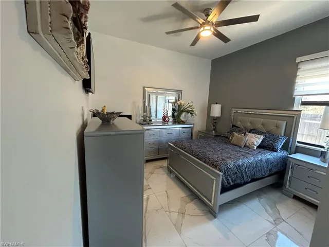 Bedroom featuring light marble finish flooring and ceiling fan