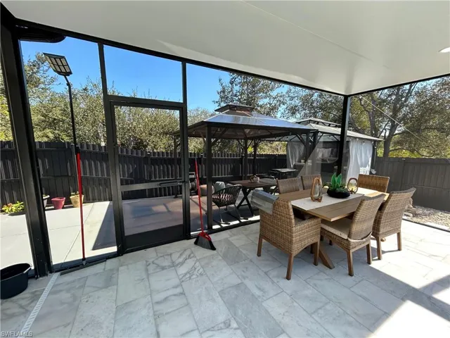Sunroom with outdoor dining area, a gazebo, and a patio area