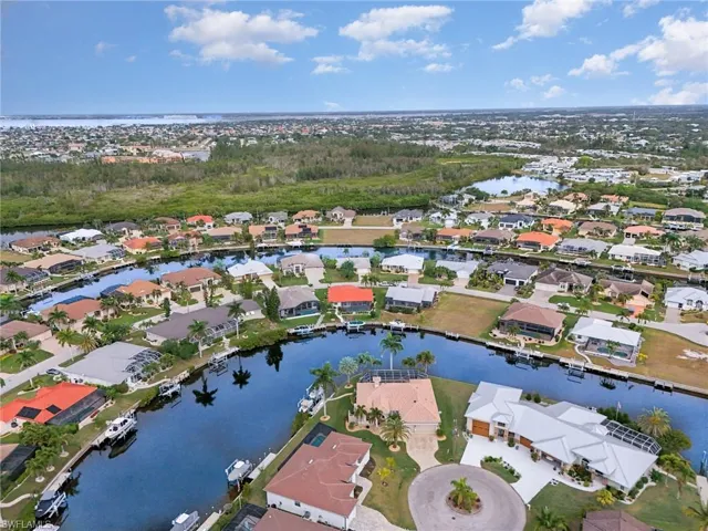 Aerial view of property's location featuring a nearby body of water and nearby suburban area