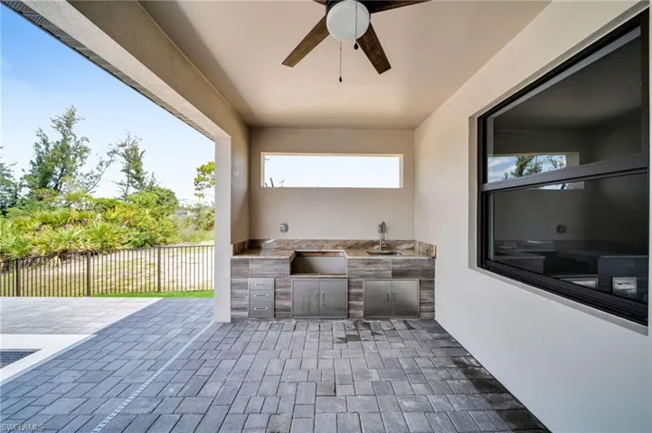 View of patio with an outdoor kitchen and a ceiling fan