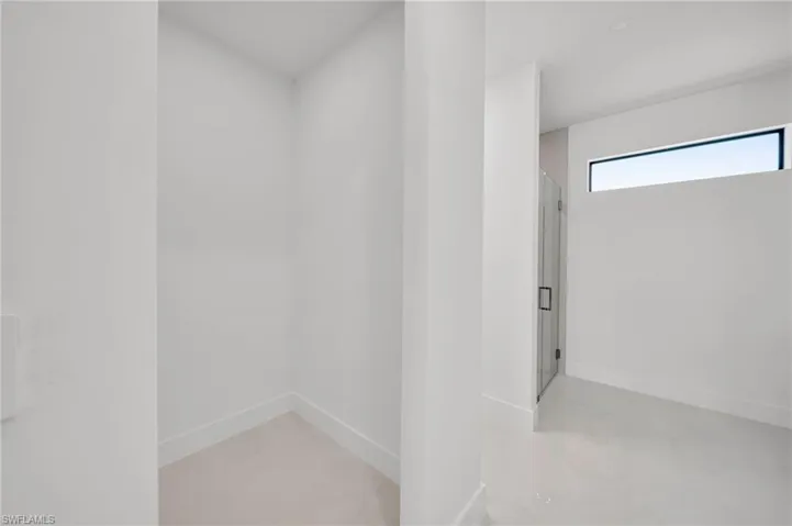 Bathroom featuring baseboards and a shower with shower door
