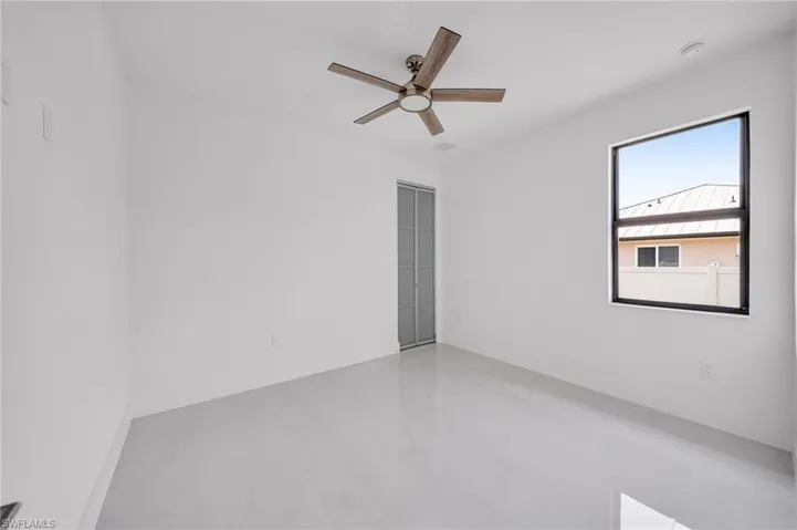 Unfurnished room with a ceiling fan and a smoke detector