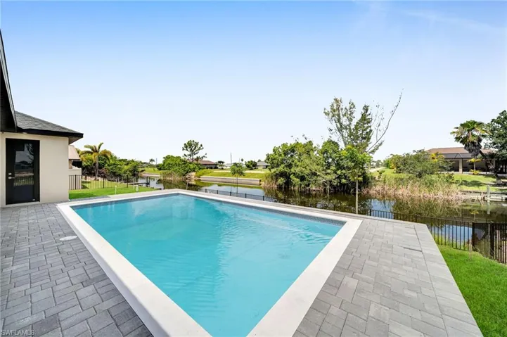 View of pool with a water view and a patio