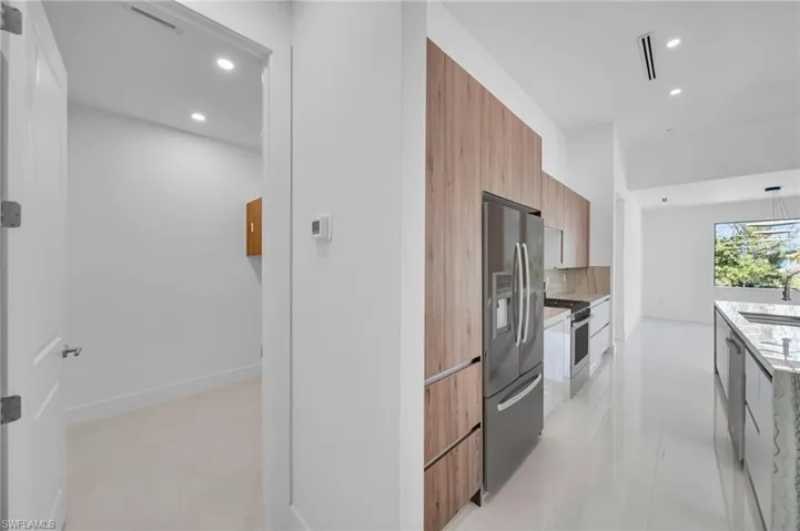 Kitchen with modern cabinets, stainless steel appliances, recessed lighting, decorative backsplash, and brown cabinets