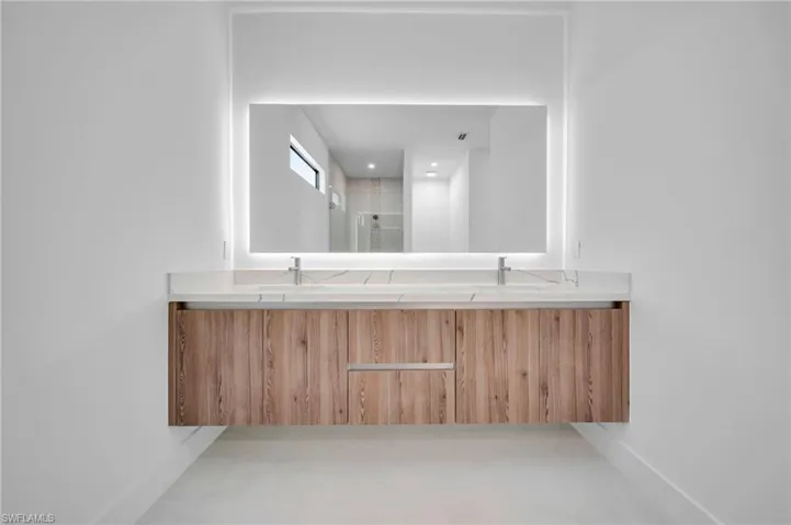 Full bath featuring double vanity and a shower with door