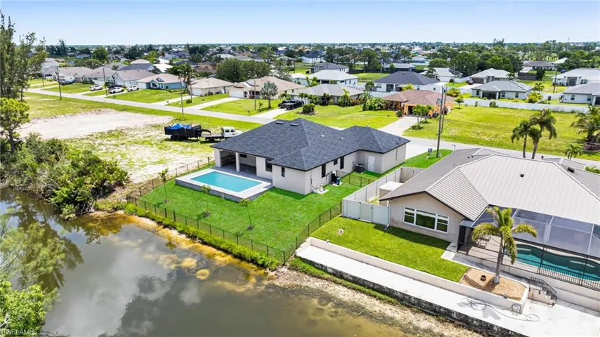 Aerial view of residential area with a large body of water and a pool area