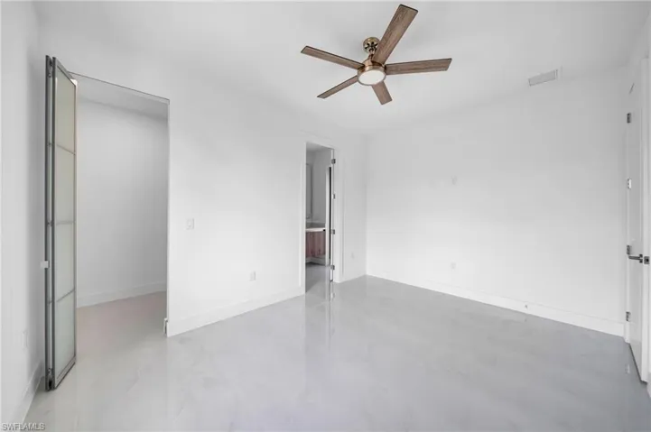 Unfurnished bedroom featuring ceiling fan and connected bathroom