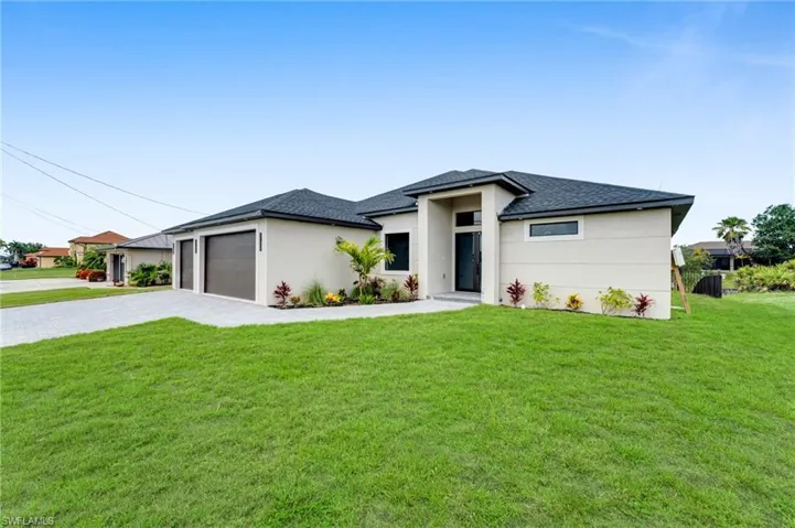 Prairie-style home featuring an attached garage, stucco siding, decorative driveway, and a shingled roof