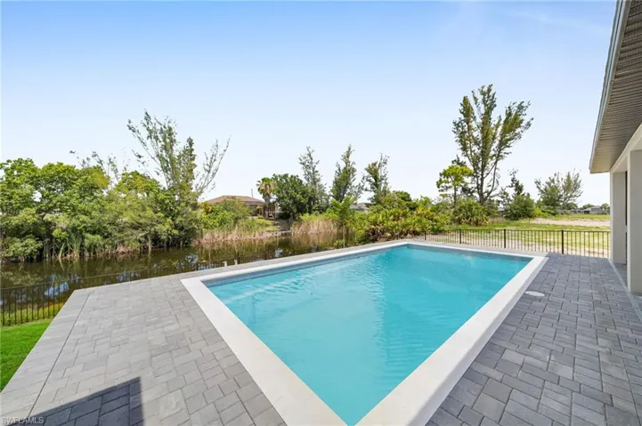 View of swimming pool featuring a water view and a patio area