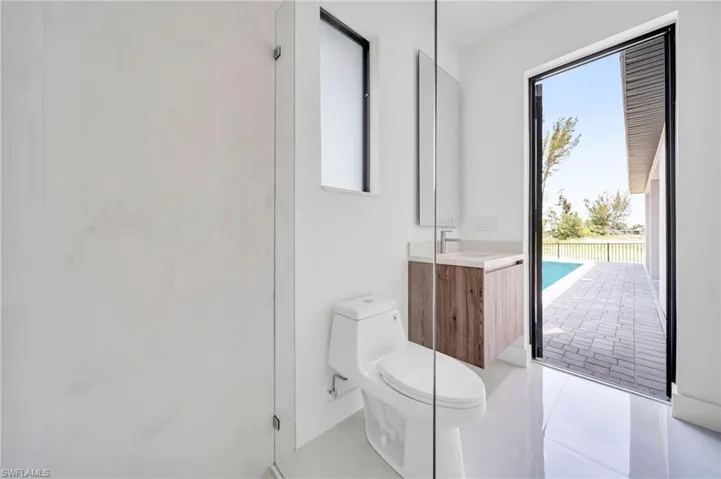 Bathroom with vanity, plenty of natural light, tile patterned flooring, and a shower