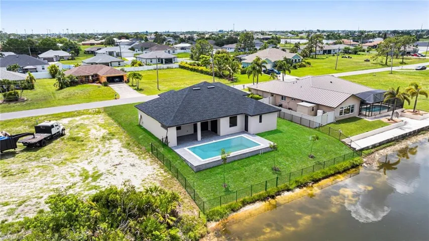 Aerial perspective of suburban area featuring a large body of water and a pool