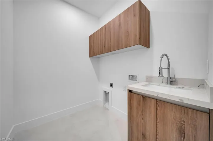 Laundry area featuring cabinet space, electric dryer hookup, washer hookup, and light marble finish flooring