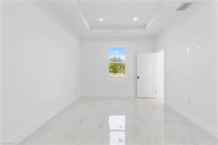 Empty room with a raised ceiling and recessed lighting