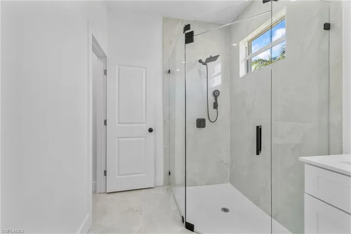Full bath with a marble finish shower and vanity