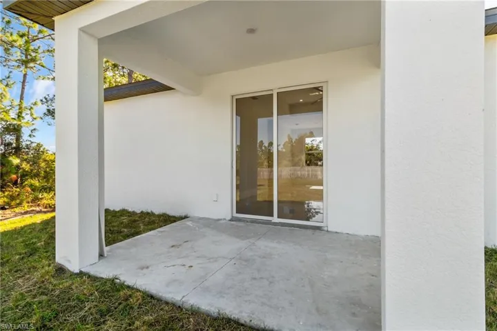 Property entrance with a patio area and stucco siding