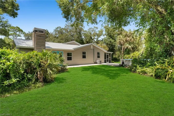Side yard view with lots of shade with mature trees and above ground pool.