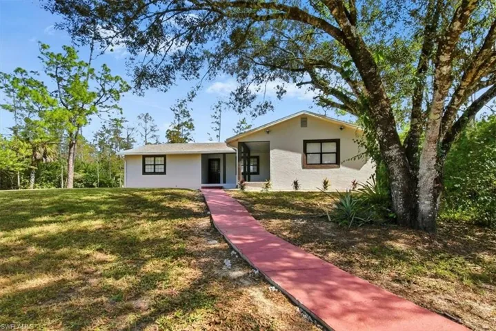 View of front facade with a front yard and stucco siding