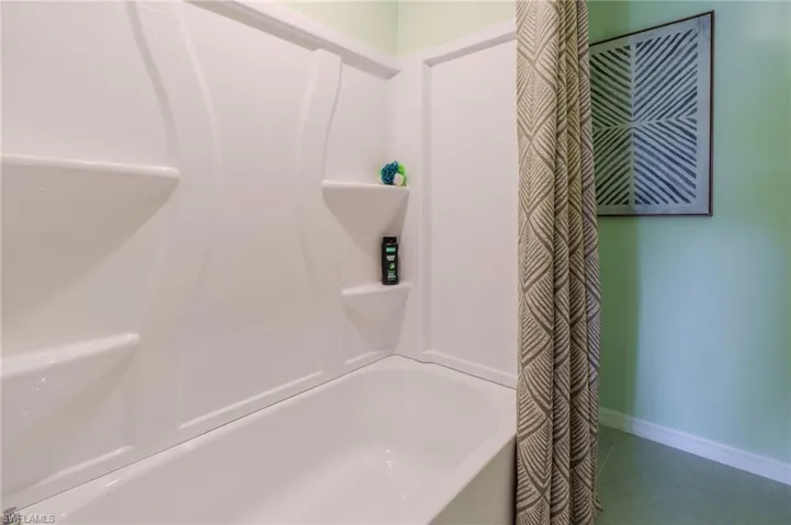 White integrated tub and shower unit featuring built-in shelving