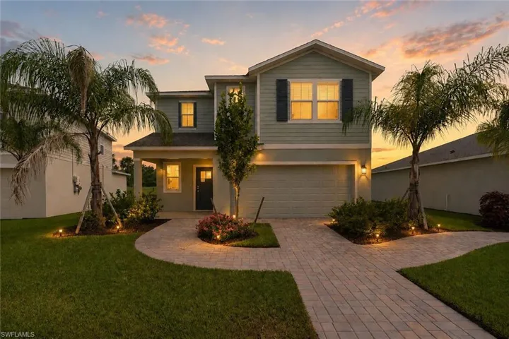 Two-story residence featuring light green siding and dark shutters
