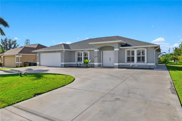 Ranch-style home featuring a garage and a front lawn