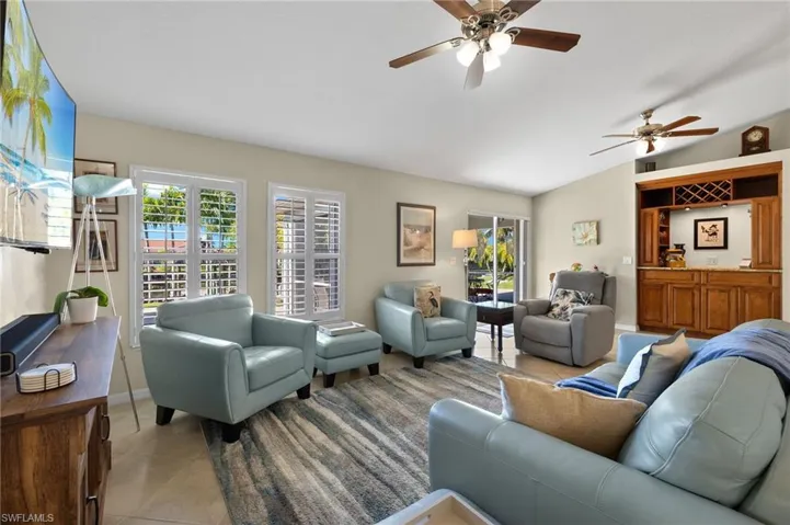 Tiled living room featuring lofted ceiling and ceiling fan